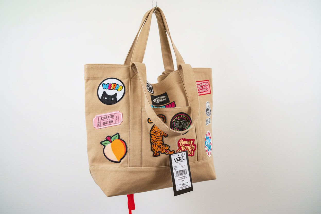 Checkered tote bag with various patches and a visible Vans tag.